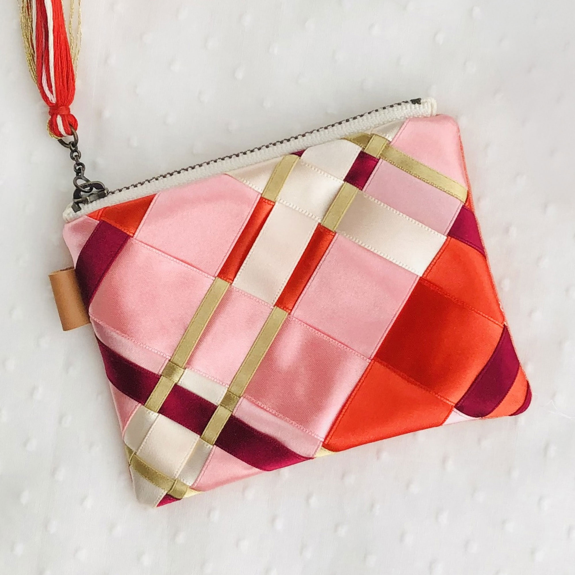 And.Mの作品。赤とピンクのチェック柄のポーチ。